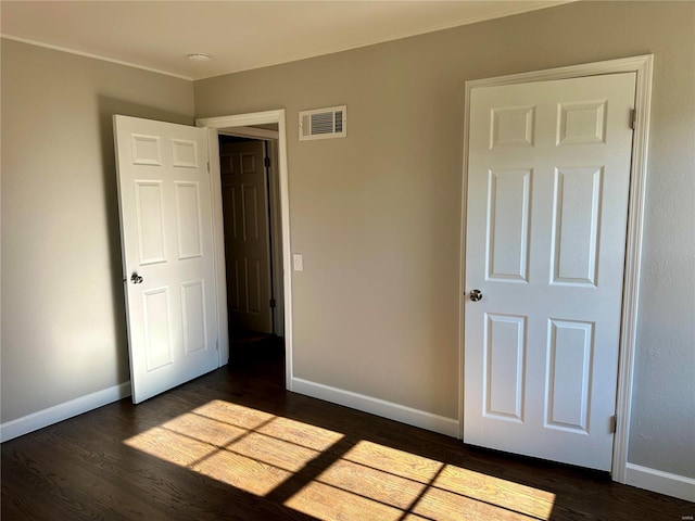 unfurnished bedroom featuring dark hardwood / wood-style flooring