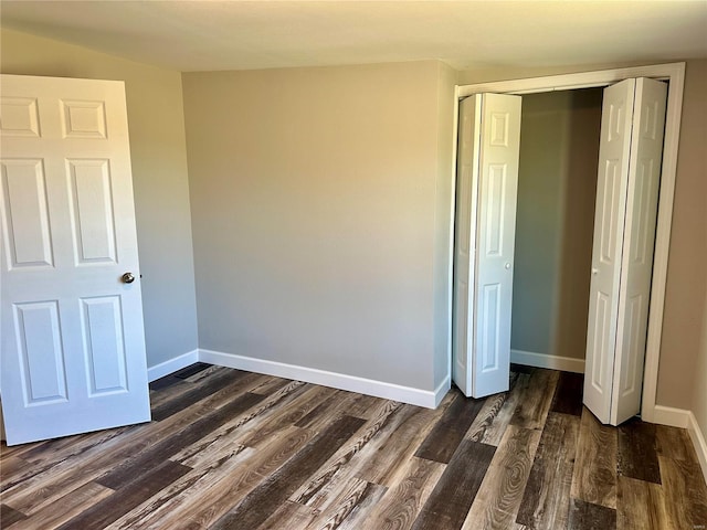 unfurnished bedroom with dark hardwood / wood-style flooring and a closet