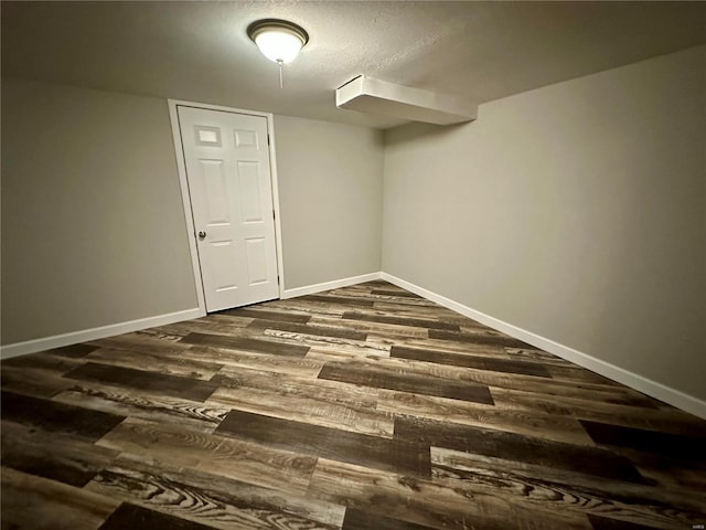 basement featuring dark hardwood / wood-style floors and a textured ceiling