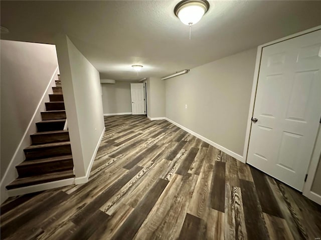 basement featuring dark hardwood / wood-style floors and a textured ceiling