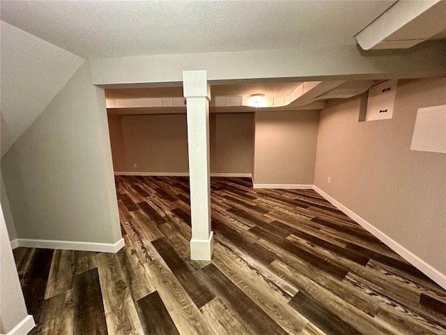 basement featuring dark wood-type flooring and a textured ceiling