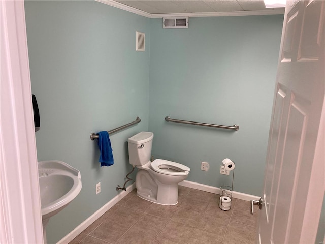 bathroom with tile patterned floors, toilet, and crown molding