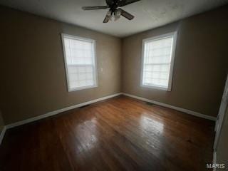 spare room featuring ceiling fan and dark wood-type flooring