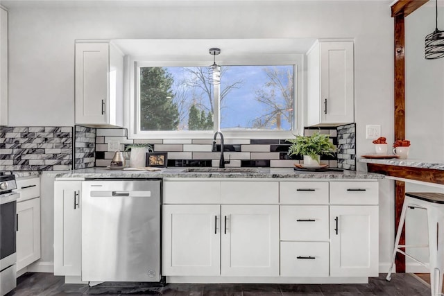 kitchen featuring appliances with stainless steel finishes, tasteful backsplash, sink, decorative light fixtures, and white cabinets