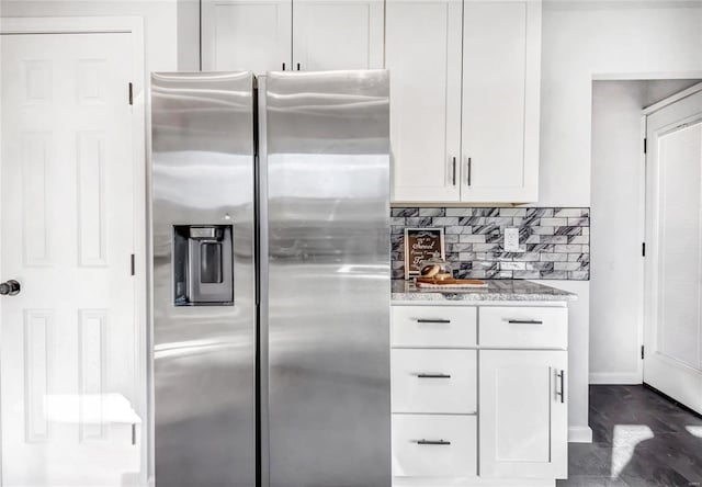 kitchen featuring backsplash, white cabinetry, light stone countertops, and stainless steel refrigerator with ice dispenser