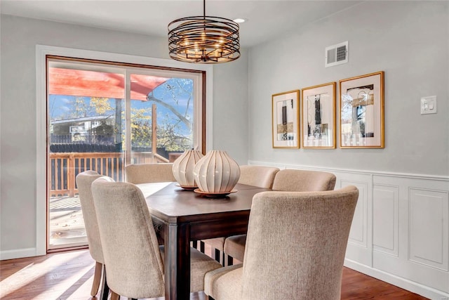 dining space with wood-type flooring and an inviting chandelier