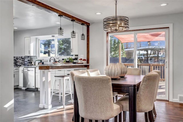 dining room featuring sink, dark wood-type flooring, and a notable chandelier