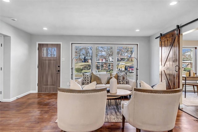 living room featuring a barn door and dark hardwood / wood-style flooring