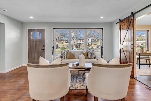 living room with a barn door and dark hardwood / wood-style flooring