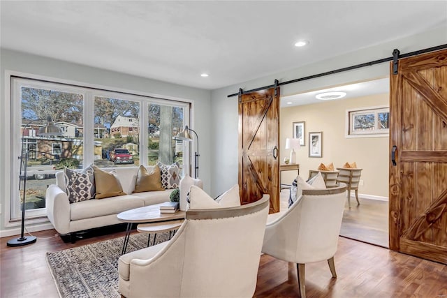 living room featuring a barn door and hardwood / wood-style flooring