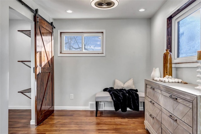 interior space with a barn door and dark wood-type flooring