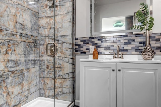 bathroom with vanity, decorative backsplash, and a shower with door