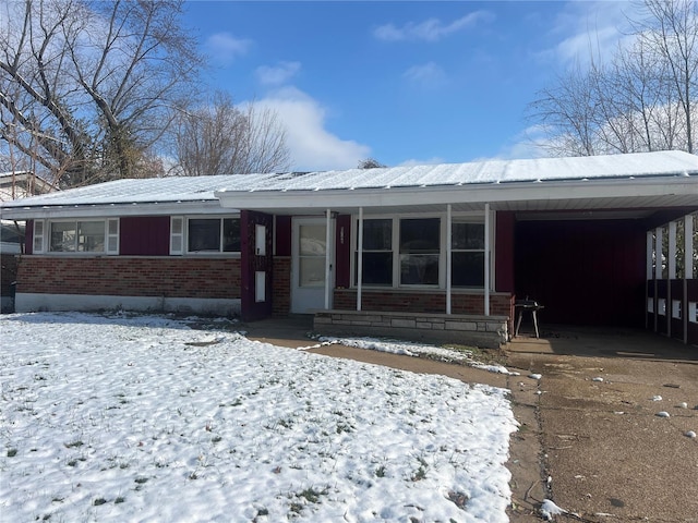 snow covered house with a carport