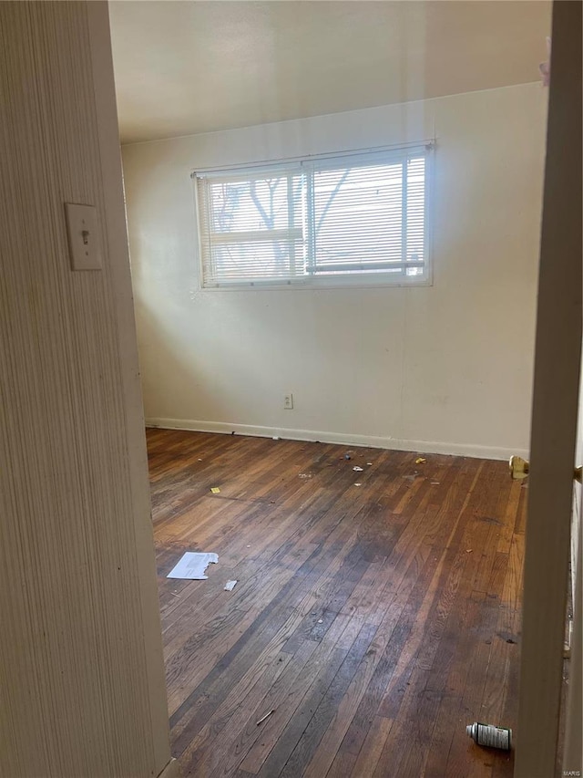 unfurnished room featuring a healthy amount of sunlight and dark wood-type flooring