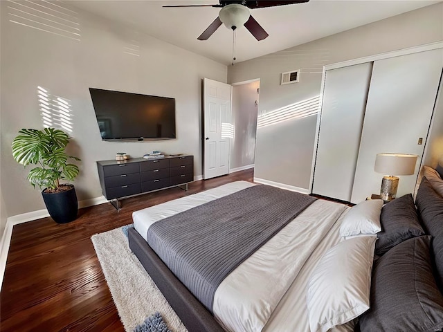 bedroom with a ceiling fan, baseboards, visible vents, dark wood-style flooring, and a closet