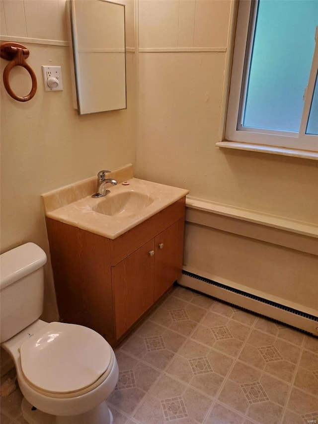 bathroom featuring vanity, toilet, and baseboard heating