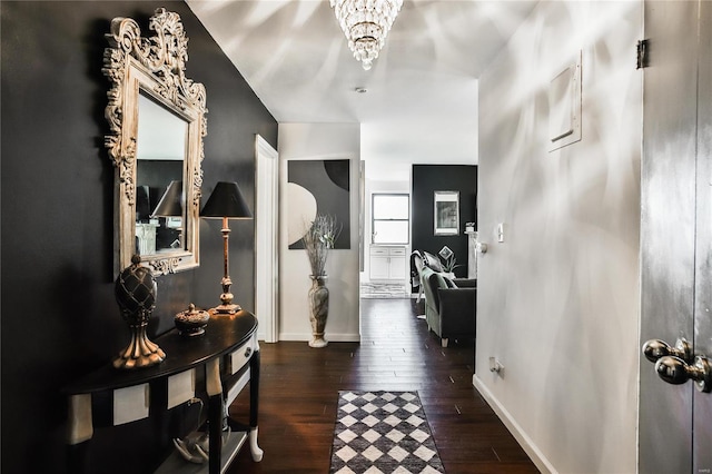 hallway featuring dark hardwood / wood-style flooring and an inviting chandelier