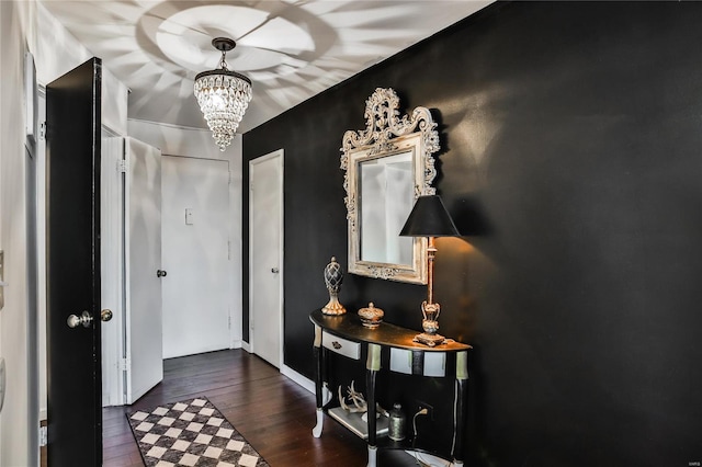 entryway with dark hardwood / wood-style flooring and a chandelier