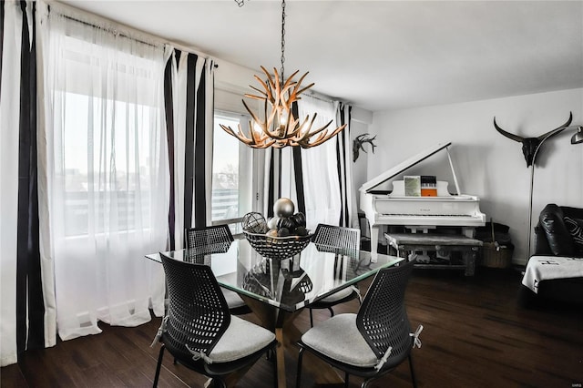 dining room featuring a healthy amount of sunlight, a notable chandelier, and dark hardwood / wood-style floors