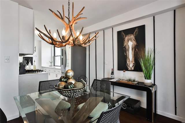 dining area with dark hardwood / wood-style floors and an inviting chandelier