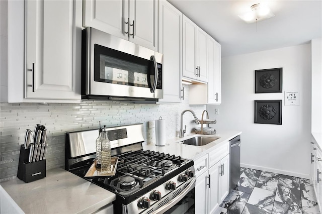 kitchen featuring sink, white cabinetry, backsplash, and stainless steel appliances