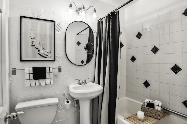 full bathroom featuring shower / bath combo with shower curtain, sink, tile walls, and toilet