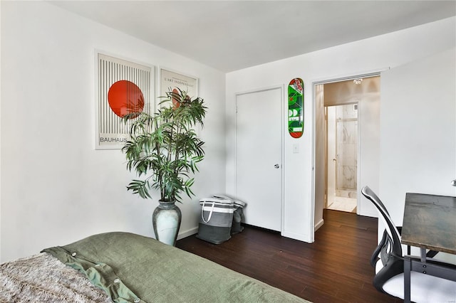 bedroom with ensuite bathroom and dark hardwood / wood-style flooring