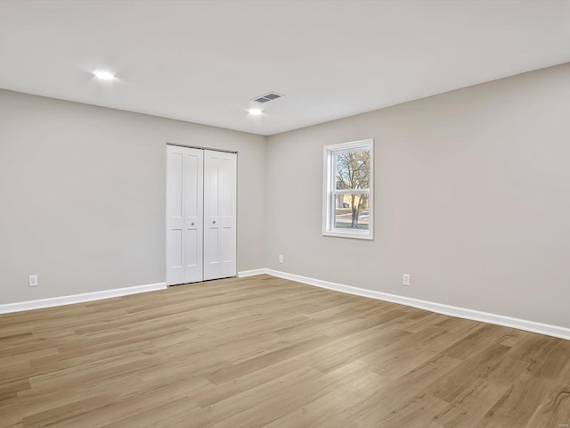 unfurnished bedroom featuring light hardwood / wood-style floors and a closet