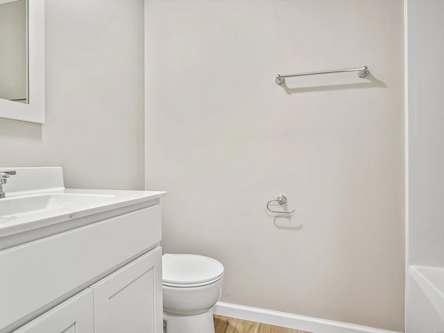 bathroom featuring wood-type flooring, toilet, and vanity