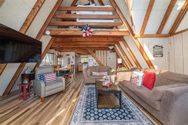 living room with lofted ceiling with beams, wood walls, and wood-type flooring