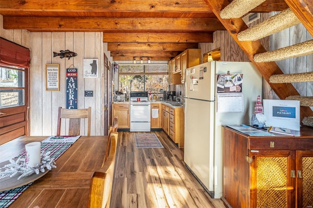 kitchen with wooden walls, beamed ceiling, light hardwood / wood-style floors, and white appliances