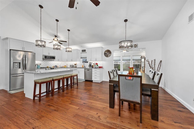 dining room with dark hardwood / wood-style floors and lofted ceiling