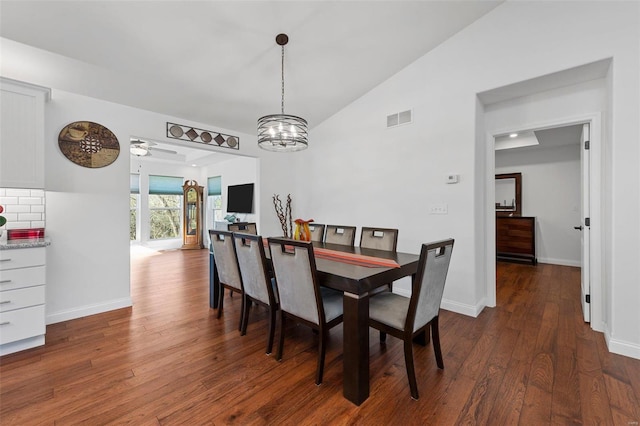 dining area with ceiling fan with notable chandelier, dark hardwood / wood-style flooring, and lofted ceiling