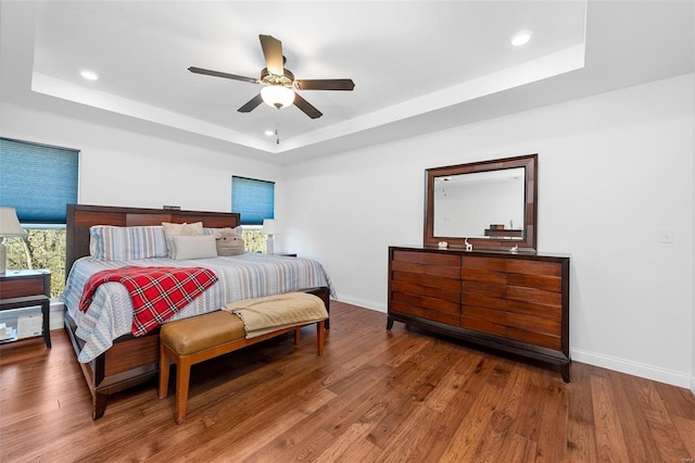 bedroom featuring hardwood / wood-style flooring and a tray ceiling