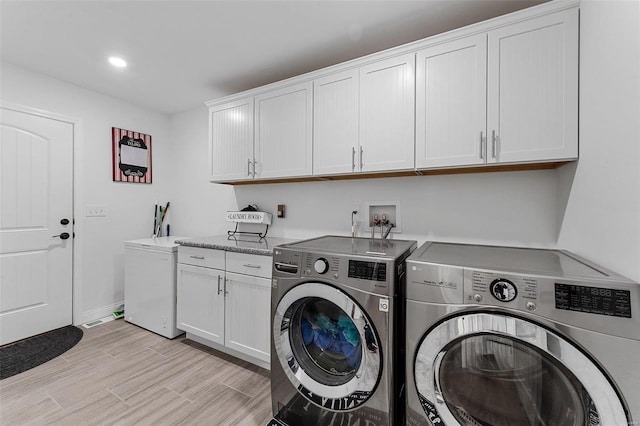 laundry room with washer and clothes dryer and cabinets