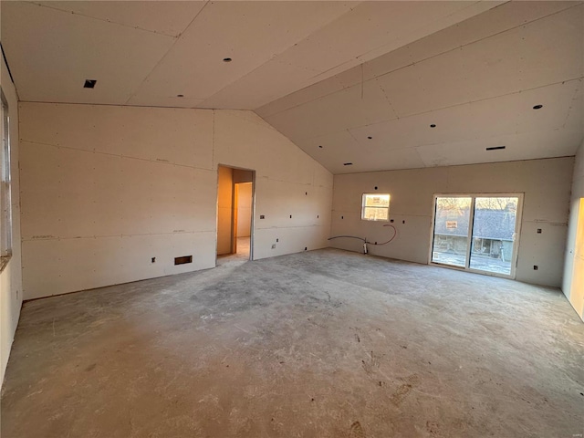 spare room featuring concrete flooring and vaulted ceiling