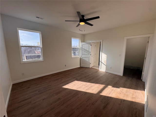 unfurnished bedroom featuring ceiling fan, wood finished floors, visible vents, and baseboards