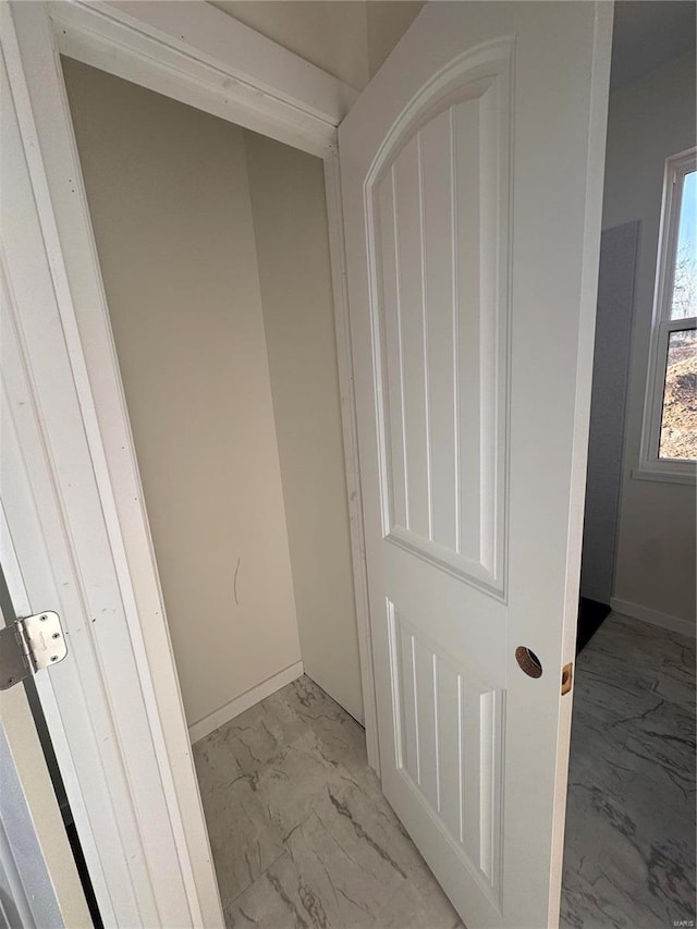 interior space with baseboards and marble finish floor