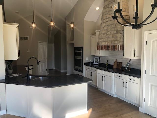 kitchen with white cabinetry, a notable chandelier, and sink