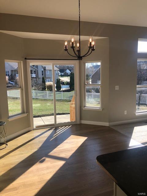 unfurnished dining area featuring hardwood / wood-style floors and a notable chandelier