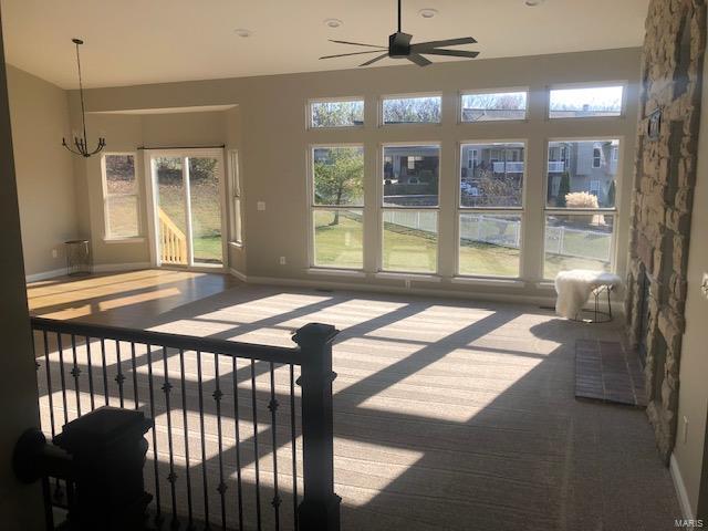 sunroom / solarium with ceiling fan with notable chandelier