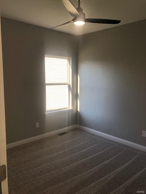 carpeted spare room with ceiling fan