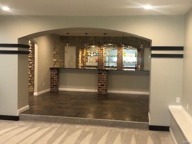 bar featuring carpet flooring and hanging light fixtures