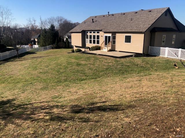 rear view of property with a lawn and a patio area