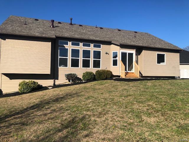 rear view of house featuring a lawn