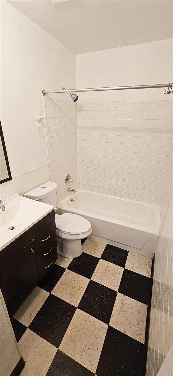 full bathroom with toilet, vanity, and tiled shower / bath