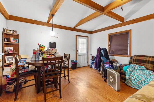 dining area featuring vaulted ceiling with beams and light wood-type flooring