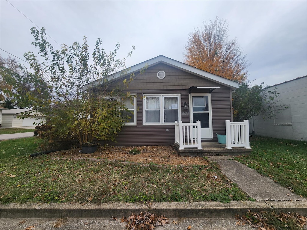 bungalow-style house with a front lawn