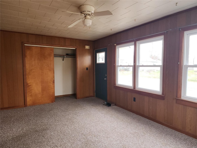 unfurnished bedroom featuring ceiling fan, light colored carpet, multiple windows, and a closet