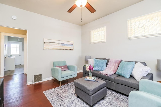 living room featuring ceiling fan and dark wood-type flooring